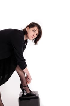 young brunette woman looking like a nanny or widow wearing a black shoe