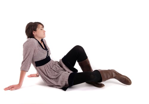 young brunette woman in dress sitting on the ground with boots