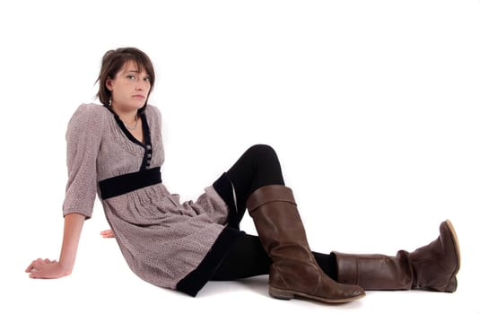 young brunette woman in dress sitting on the ground with boots