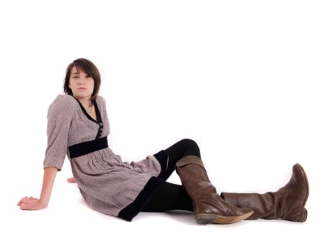 young brunette woman in dress sitting on the ground with boots