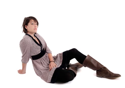 young brunette woman in dress sitting on the ground with boots