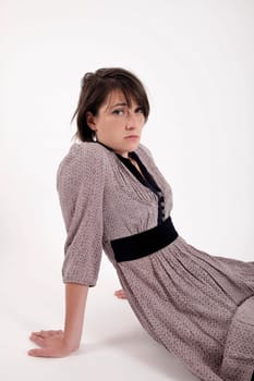 young brunette woman in dress sitting on the ground with boots