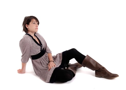young brunette woman in dress sitting on the ground with boots
