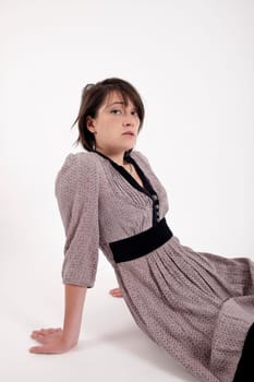 young brunette woman in dress sitting on the ground with boots