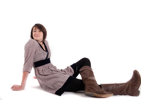 young brunette woman in dress sitting on the ground with boots