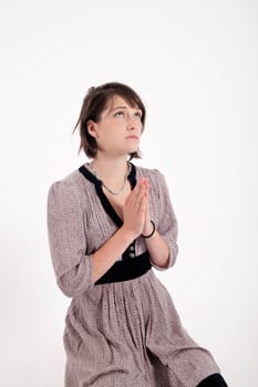 portrait of a young brunette woman requesting in catholic posture united hand