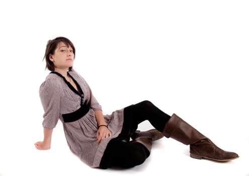 young brunette woman in dress sitting on the ground with boots