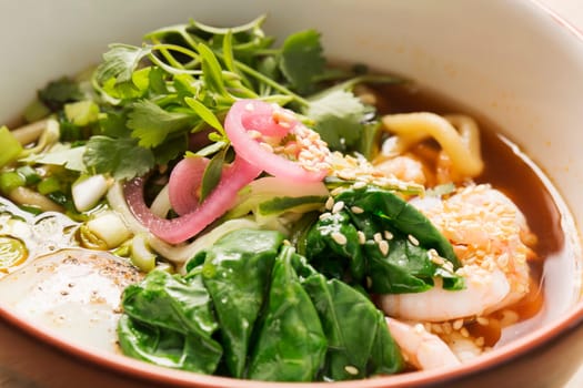 Bowl with broth and spoon filled with it