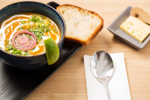 Ceramic bowl with reflective soup and chromed spoon