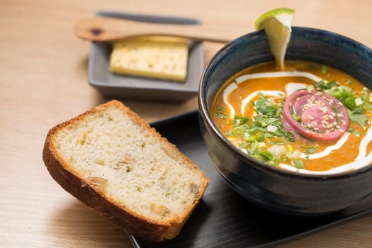 Ceramic bowl with delicious soup and bread slice