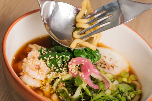 Ceramic bowl with broth, shrimp and  fesh vegetables