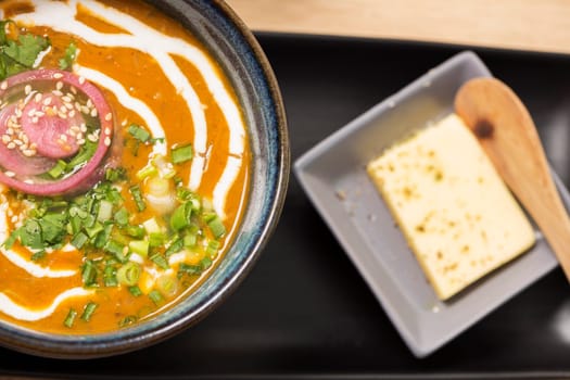 Zoomed bowl with reflective soup and melted butter