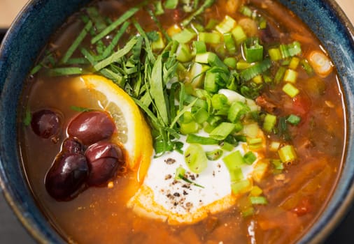 Zoomed bowl with hot soup with tasty fillings