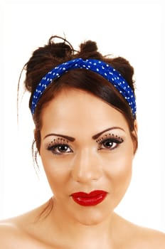 A closeup heat shoot of a gorgeous woman with long eyelashes and red lips and a blue headband in her hair.