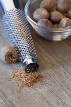 Nutmeg in a bowl next to it a shoot and powder