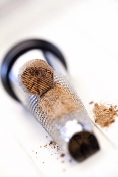 Nutmeg lies on a nutmeg grater on a white background