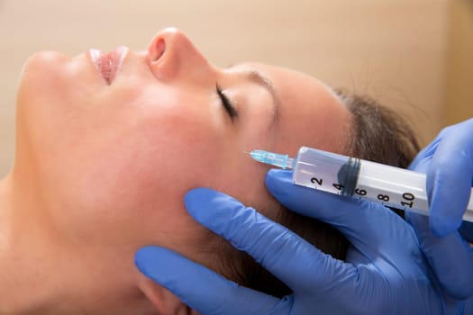 Anti aging facial mesotherapy with syringe closeup  on woman face