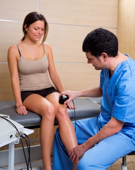 Ultrasonic therapy machine treatment doctor and woman patient on her knee