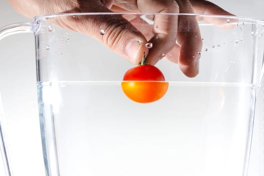 hand that is throwing a tomato in water