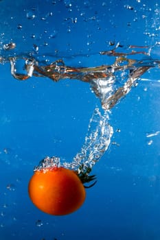red tomato dropped into the water