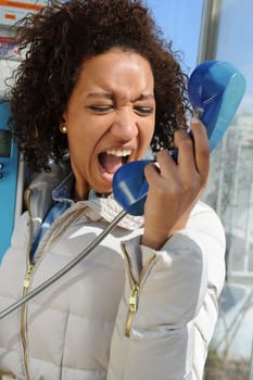 Jeune femme dans une cabine téléphonique