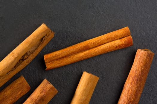 Cinnamon spice macro closeup detail on black slate stone background