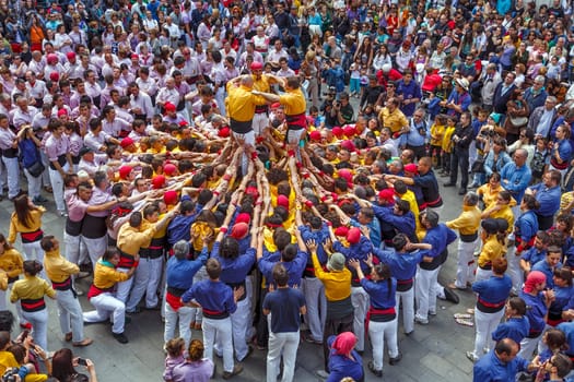 BARCELONA, SPAIN - MAY 19: Some unidentified people called Castellers do a Castell or Human Tower, typical tradition in Catalonia, on May 19, 2013 in Barcelona, Spain.