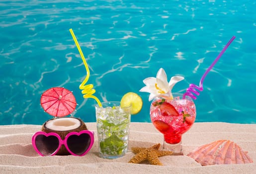 Mojito and strawberry cocktails on white sand beach and turquoise sea