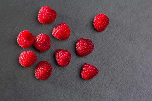 berries raspberry on black slate background macro closeup