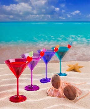 colorful cocktail in a row with cherry on tropical sand beach of turquoise sea