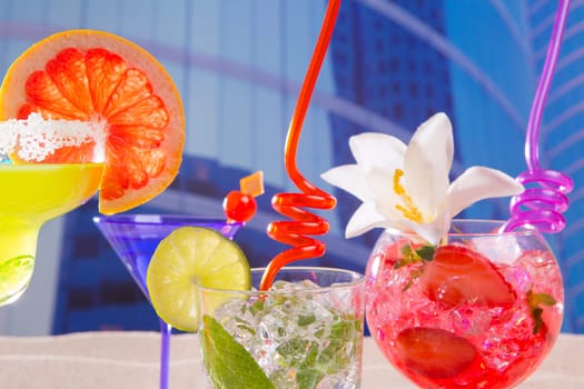 Colorful tropical cocktails in summer at urban city buildings