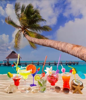 Colorful tropical cocktails at beach on white sand and palm tree