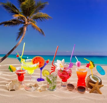 Colorful tropical cocktails at beach on white sand and palm tree