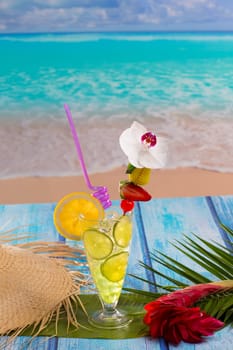 Lemon lime cocktail mojito on tropical turquoise beach on blue wood