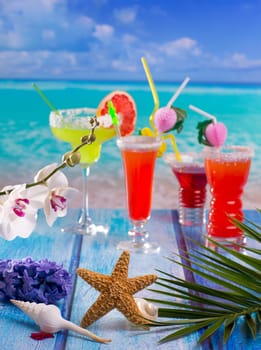 Cocktails margarita sex on the beach in colorful tropical house with flowers starfish and seashells