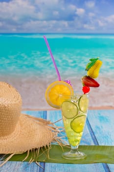Lemon lime cocktail mojito on tropical turquoise beach on blue wood