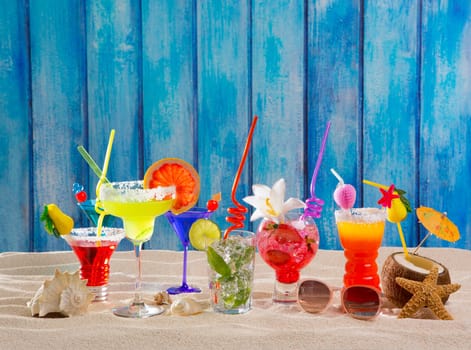 Colorful tropical cocktails at beach on blue grunge wood wall
