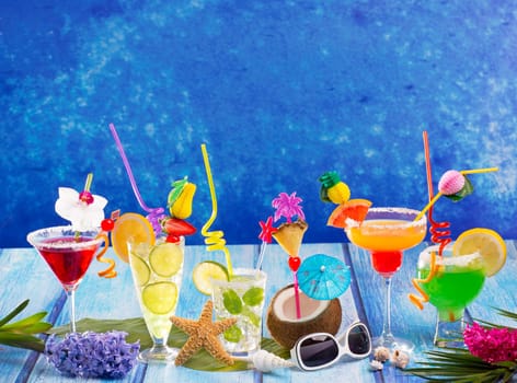 Colorful varied tropical Cocktails in tropical blue wood with coconut mojito pepermint margarita