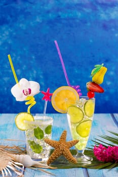 Mojito and lemon lime Cocktails in tropical Caribbean blue wood with starfish flowers and seashells