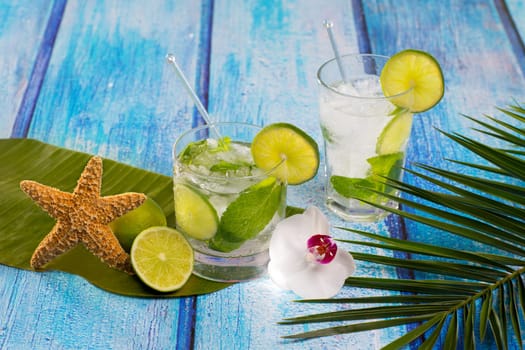 Cuban Mojito cocktail in tropical blue wood with flowers and starfish