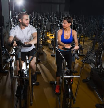 elliptical walker trainer man and woman at black gym training aerobics exercise