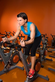Aerobics spinning woman exercise workout at orange bikes gym