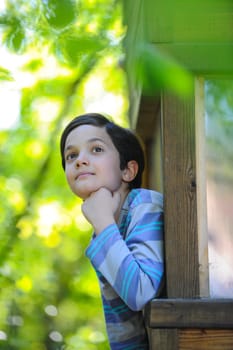 Enfant observant la nature dans sa cabane