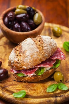 Whole grain sandwich with Italian salami, goat cheese and fresh olives