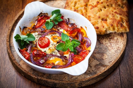Baked feta cheese on vegetables and olive bread