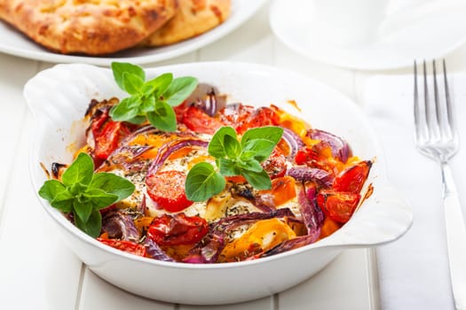 Baked feta cheese on vegetables and olive bread