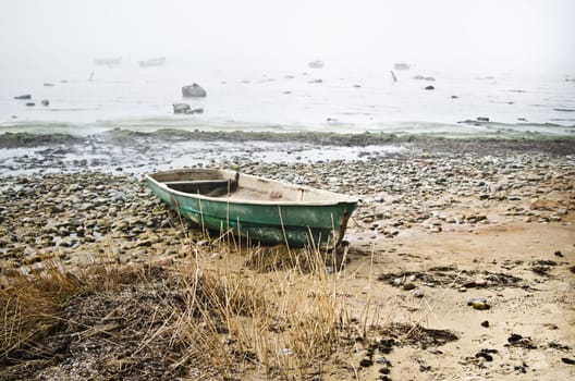 Old fishing boat at coast foggy in the morning