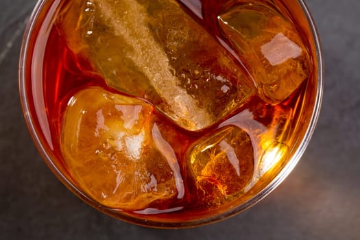 Whiskey whisky on the rocks on glass over gray black background
