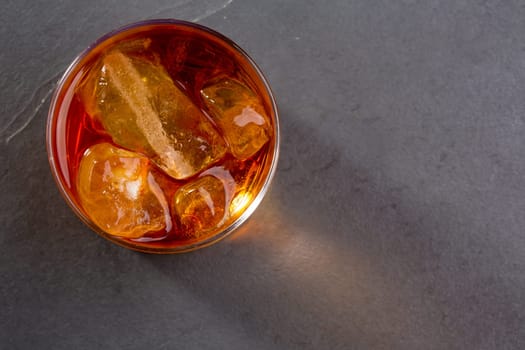 Whiskey whisky on the rocks on glass over gray black background