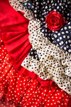 Flamenco dresses in red and blue with spot with red rose typical from Spain Espana